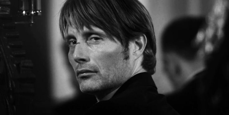 Black and white portrait of Mads Mikkelsen looking over his shoulder
